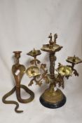 An Islamic style five branch brass candlestick with a brass cobra candlestick.