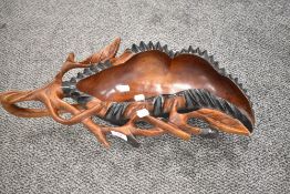 A 20th century hand carved wooden bowl on tribal and ethnic interest. Having hooped handle and