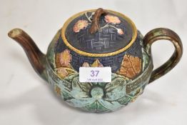 A Victorian Majolica style tea pot having lozenge stamp to base, damage and repair to handle.
