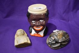 Two Egyptian items including stone carved scarab beetle and a bust with a vintage character mug.