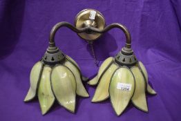 A modern wall mounted light with double branch in the form of a lily with coloured leaded light