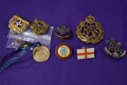 A selection of military themed badges including an RAF cap badge.