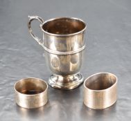 A George V silver cup, of cylindrical form with flared rim, moulded band and applied scroll