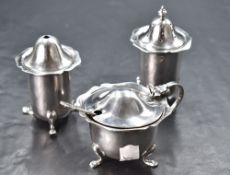 A George V silver three-piece condiment set, comprising salt cellar, pepperette and mustard, each of
