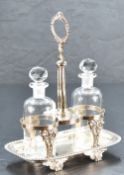 A late Victorian silver two-bottle oil and vinegar cruet, having a central raised handle between two