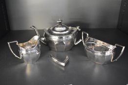A three piece silver tea set of tapered oval form having pressed decoration to rim, Chester 1921,
