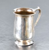 A George V silver cup, of cylindrical form with flared rim, angular handle and short stepped