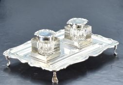 An early 20th century silver inkstand, of rectangular form with shaped and moulded outline, two