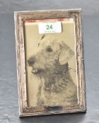 A George V silver photograph frame, of rectangular form with flower ornamented reeded outline,