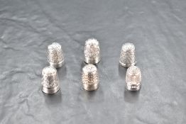Two hallmarked silver thimbles, one 'sterling silver' The Spa thimble (15grams gross) and three