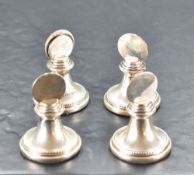 Four Queen Elizabeth II silver menu holders, of bead and ring moulded pedestal form with circular