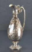 A Victorian silver ewer, of ovoid form with shaped spout and hinged cover over a body embossed