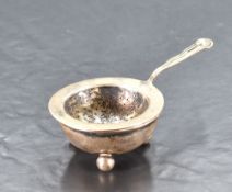 An early 20th century Dutch silver straining spoon and stand, the dished and pierced circular