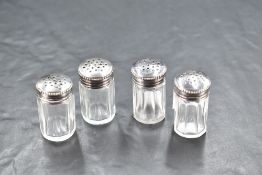 A group of four continental white metal topped clear glass condiments, of octagonal cut