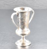 A George V silver trophy, of elongated urn-form with shaped scroll handles and circular foot,