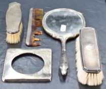 A silver mounted two-piece dressing table set, comprising hand mirror and clothes brush, each with