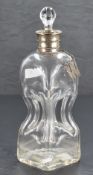 A white metal mounted glass decanter, having an associated glass stopper over the flared and bead