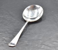 An Art Deco silver serving spoon, with simple engraved decoration, marks for Sheffield 1935, maker