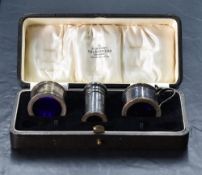A George V silver three piece condiment set, comprising salt, peperette and mustard, each of