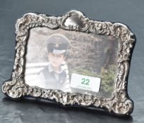 A Queen Elizabeth II silver mounted photograph frame, of shaped rectangular form embossed throughout