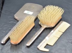 A George VI silver backed four-piece brush set, of Art Deco influenced design, comprising hand