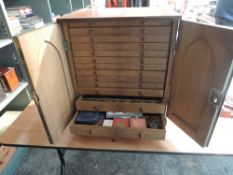 A large 13 Drawer Wooden Coin Cabinet containing a large collection of World Coins