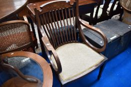 An Edwardian mahogany salon armchair having inlaid decoration to rail back , on tapered legs with