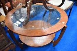 A vintage teak and glass top circular coffee table