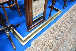 A traditional brass fire fender
