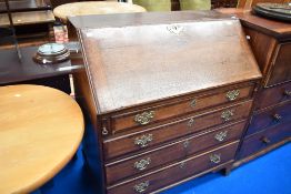 A Georgian oak bureau having fitted interior, brass handles , four drawers and bracket feet, nice