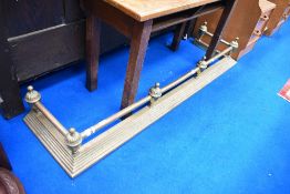 A traditional brass fire fender
