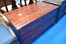 A modern storage chest having campaign style drawers and underflap storage
