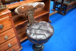 A Victorian captains style chair on cast swivel base with crown and anchor carving to back panel and