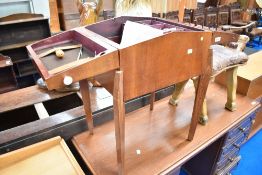 A vintage sewing box on legs, with contents