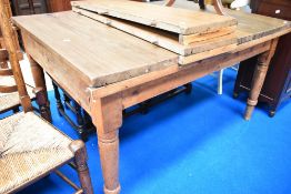 A traditional kitchen table with pine frame , turned legs and later top