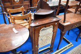 A Georgian walnut corner cabinet having mirror door