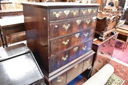 An 18th Century mahogany and walnut chest on stand having brass handles and escutcheons on