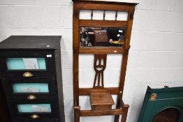 A late 19th or early 20th Century oak hall stand with mirror back wunder flap storage and twin metal