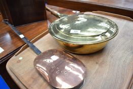 A traditional brass bed warming pan and a copper nut roaster