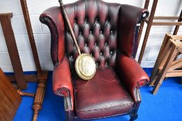A modern/vintage red leather wing back armchair