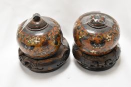 Two vintage Chinese cloisonné enamel lidded pots on carved wooden stands, having decoration of