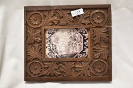 A 19th century Delft tile having Chinoiserie design in purple to white ground, mounted in carved oak
