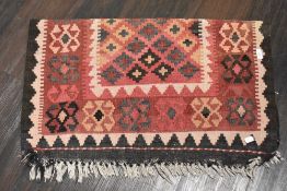 A vintage Turkish style rug in a black red and cream ground 80cm x 100cm