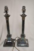 A pair of early 20th century silver plated lamp bases in the form of classical styled candlesticks.