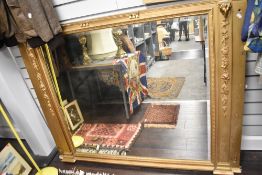 A large Victorian over mantel mirror framed by two column supports adorned with rams heads and fruit