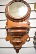 A late Victorian Mahogany hallway mirror in an ecclesiastical design with pocket shelf and formed