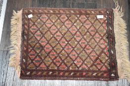 A small antique Afghan woven prayer mat or rug in deep reds with a geometric design. 65cm x 41cm
