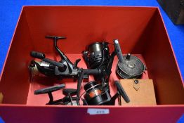 A box containing 4 spinning reels, a fly reel and a cast wallet