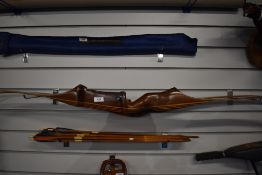 Two long bows one marked The Black Widow made by Wilson brothers along with 15 arrows
