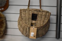 An old wicker creel containing a small selection of tackle including spinners and minnows